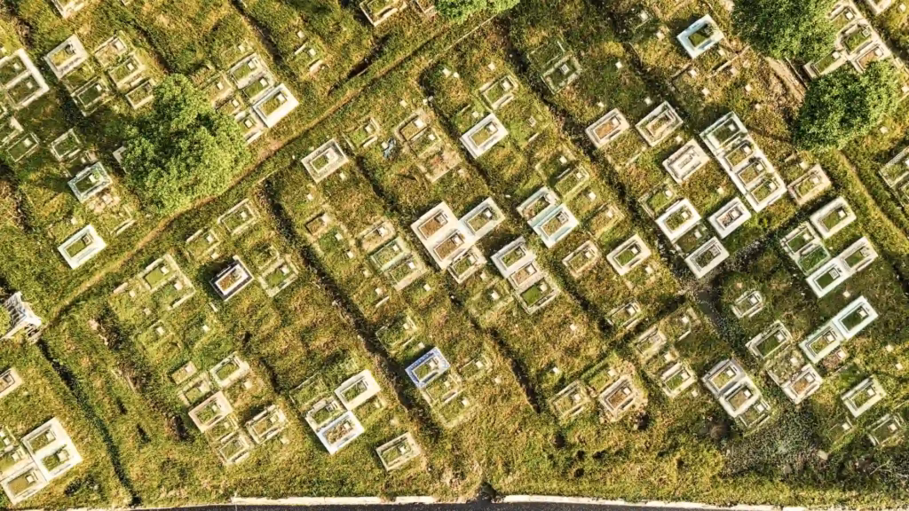 Aerial view of a cemetery with rows of graves and memorial plots arranged in a grid pattern